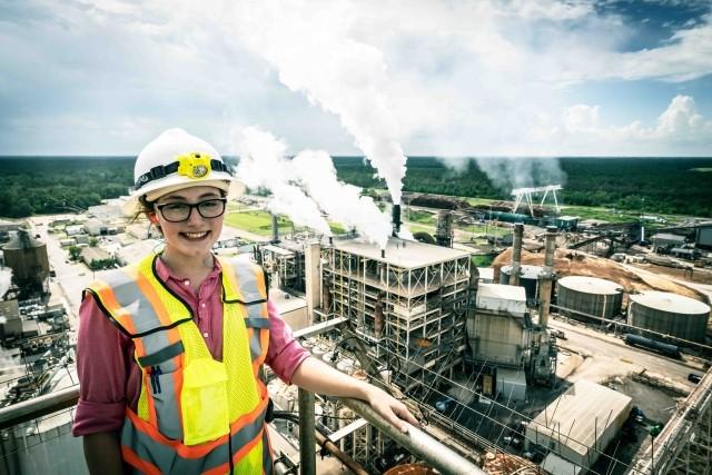 A young woman engineer overlooking a paper mill